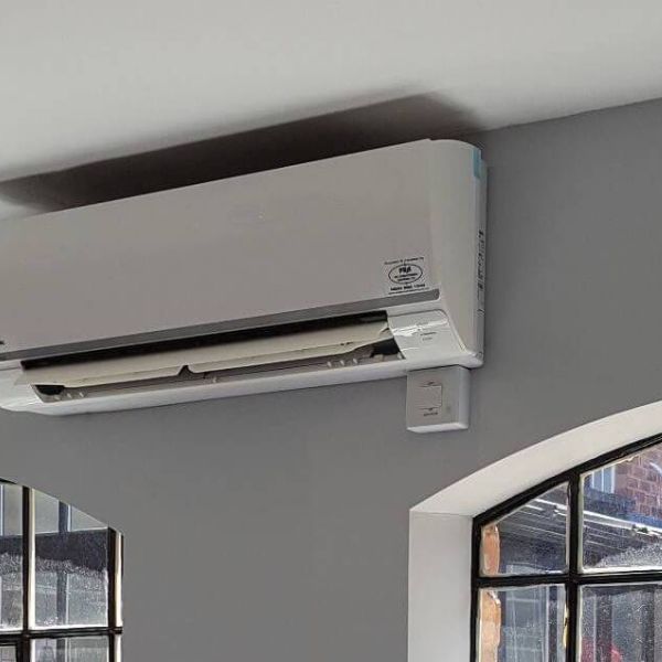 Conservatory air conditioning installation in UK home, wall mounted cooling and heating system in glass conservatory room, efficient climate control for year round comfort in conservatories www.airomax.co.uk