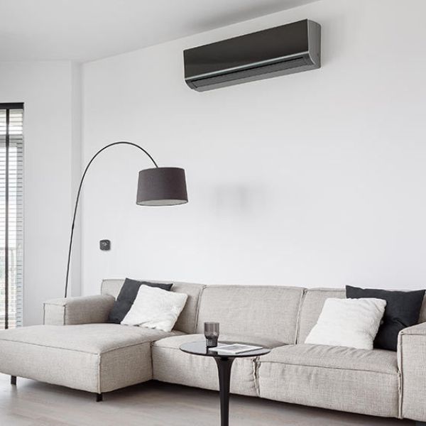 Living room air conditioning installed in UK home, sleek wall mounted cooling and heating system in modern interior, quiet energy efficient AC unit for residential living space comfort all year round www.airomax.co.uk